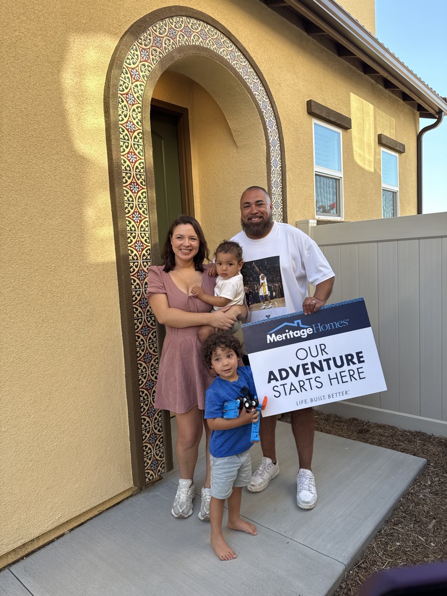 A family on closing day in front of their brand-new home